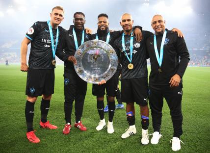 Soccer Aid for UNICEF World XI team celebrating with a trophy.