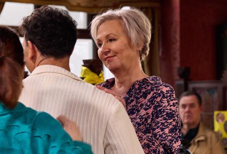 A woman listens intently as a man proposes to her.