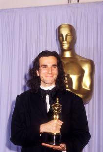 Daniel Day-Lewis holding an Academy Award.