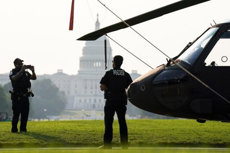 US Park Police officer next to a Black Hawk helicopter on the National Mall.