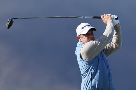 Paul McGinley teeing off at a golf tournament.