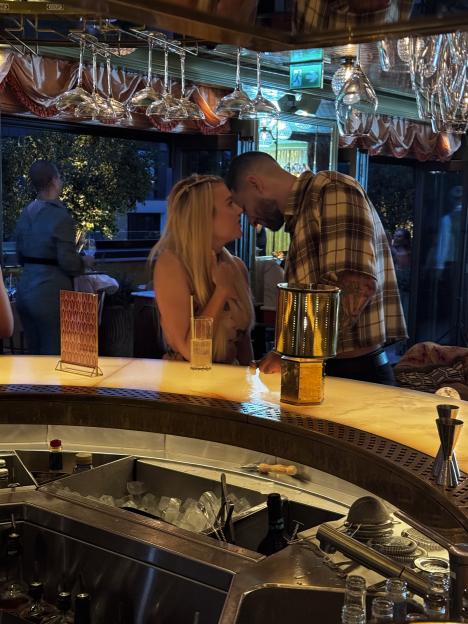 Shea from Love Island and Sacha from MAFS leaning in close to each other at a bar.