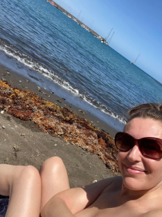 Woman sunbathing on a beach near the ocean.