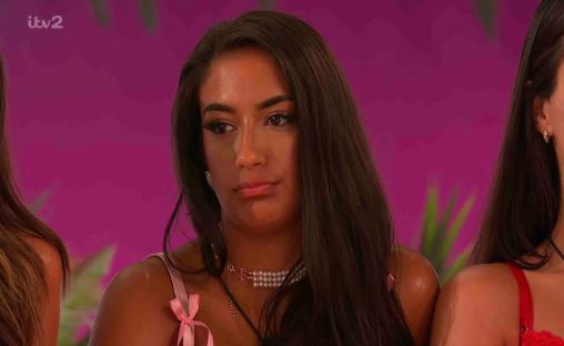 Screenshot from Love Island showing a woman with long dark hair.