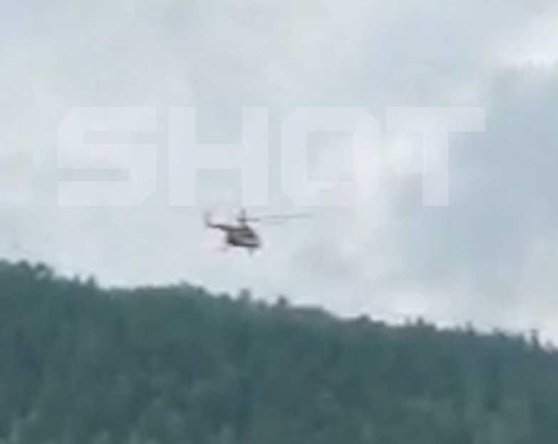 Helicopter flying over a forest.