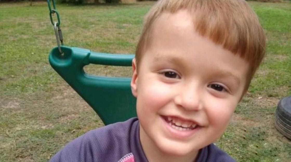 Smiling young boy on a swing.