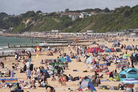 Crowded Bournemouth beach on a warm day.