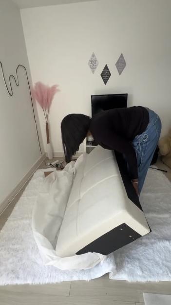 Person assembling a white couch.