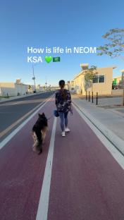 Woman walking her German Shepherd dog on a path in NEOM, KSA.