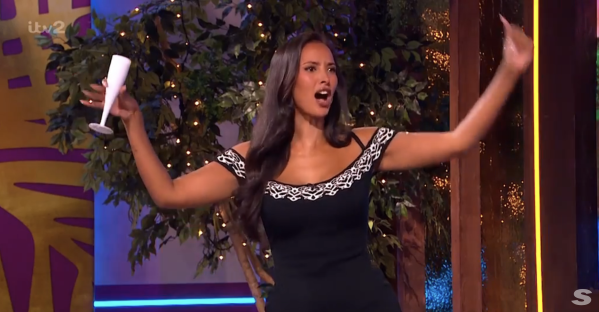 Screenshot of a woman holding a champagne flute and gesturing emphatically.
