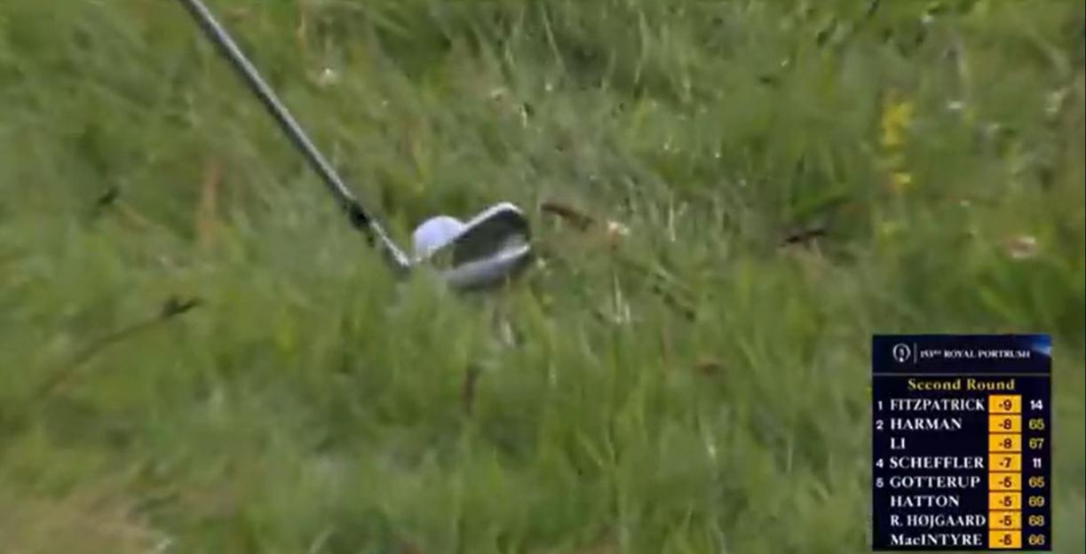 Golf club hitting a ball in the grass, with a leaderboard visible.