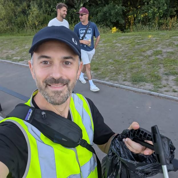 A man in a high-visibility vest and cap pretends to be a litter picker to gain entry to an Oasis concert.
