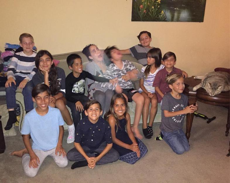 Large family group photo with children and a cat.