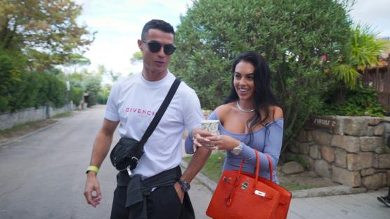 Photo of Georgina Rodriguez and Cristiano Ronaldo walking down a street.