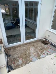 Demolished conservatory floor with exposed bamboo roots.