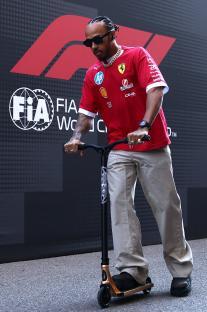 Lewis Hamilton riding a scooter before a Formula One race.