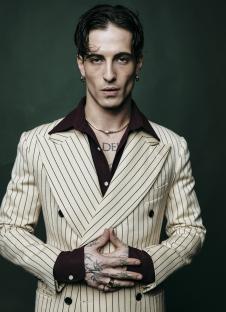 Portrait of Damiano David in a pinstripe suit.