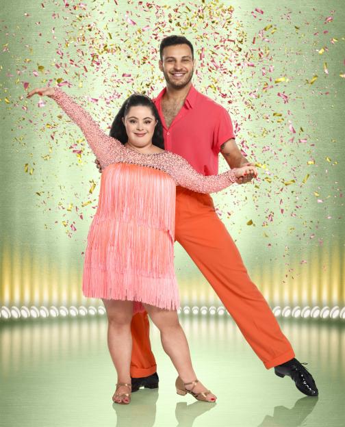 Ellie Goldstein and Vito Coppola in a dance pose with confetti falling.