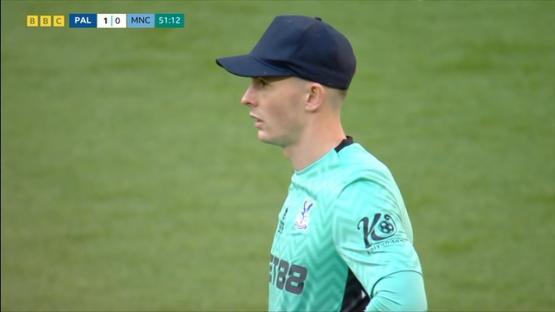 Soccer player wearing a teal jersey and a dark-colored baseball cap.