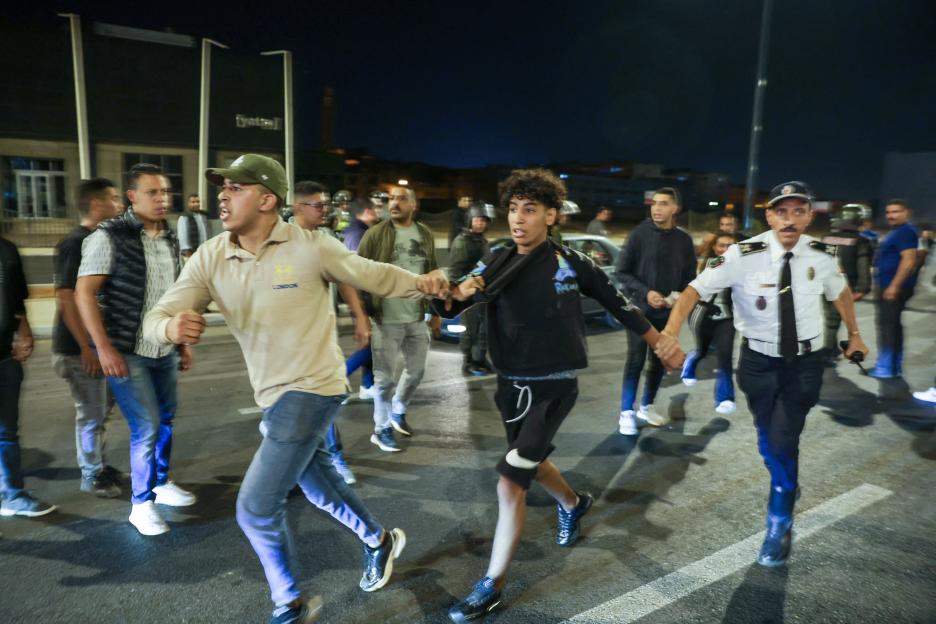 Members of security forces detain a protester during a youth-led demonstration in Sale.