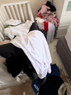 Overcrowded bedroom with baby crib and overflowing piles of clothes; text overlay reads,