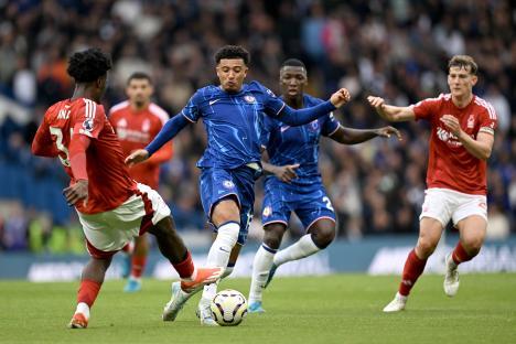 Jadon Sancho of Chelsea challenged by Ola Aina of Nottingham Forest during a Premier League match.