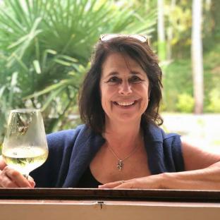 Woman holding a glass of white wine.