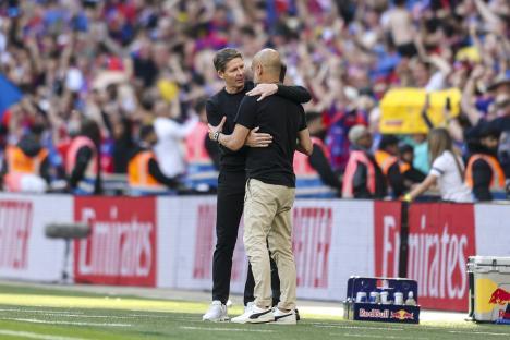 Oliver Glasner and Pep Guardiola embracing after a soccer game.