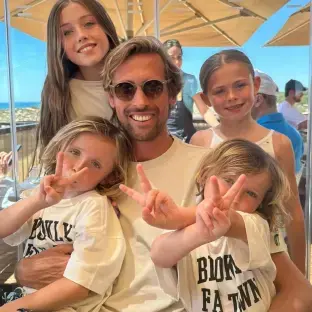 Man with four children making peace signs.