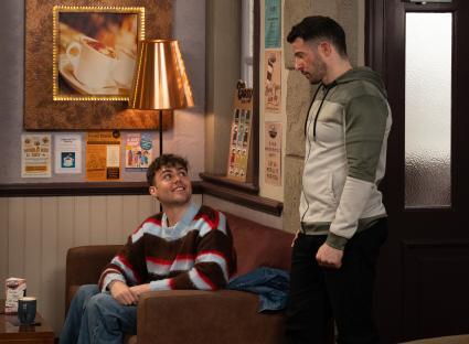 Two men talking in a cafe.
