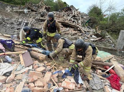 Rescuers searching through rubble at a destroyed house.