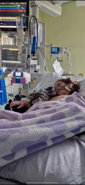 Ivy Amos, 9, paralysed from the neck down, in a hospital bed with medical equipment.