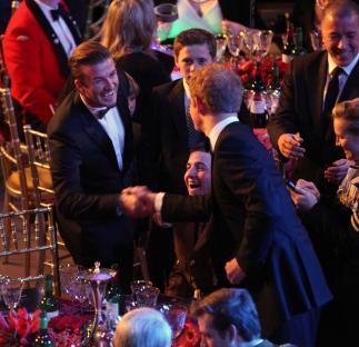 David Beckham and Prince Harry shaking hands at an awards ceremony.