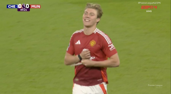 Manchester United soccer player adjusting his shirt.