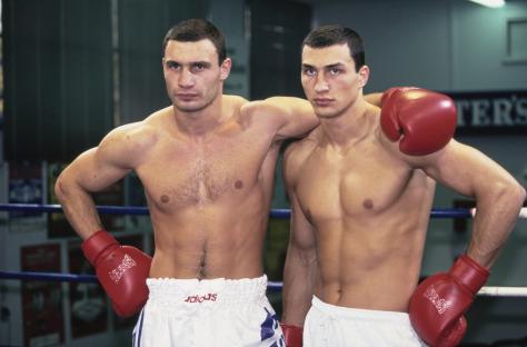 Vitali and Wladimir Klitschko, brothers and heavyweight boxers, posing together in boxing gloves and shorts.