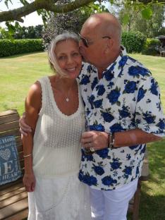 A man kissing a woman on the cheek in a garden.