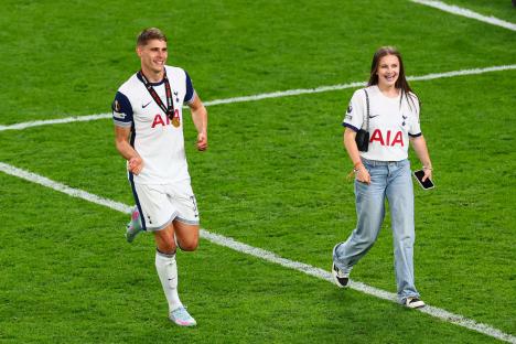 Micky van de Ven of Tottenham Hotspur celebrates after a soccer game with a companion.