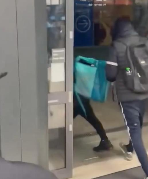 Two shoplifters running out of a store with bags full of stolen items.