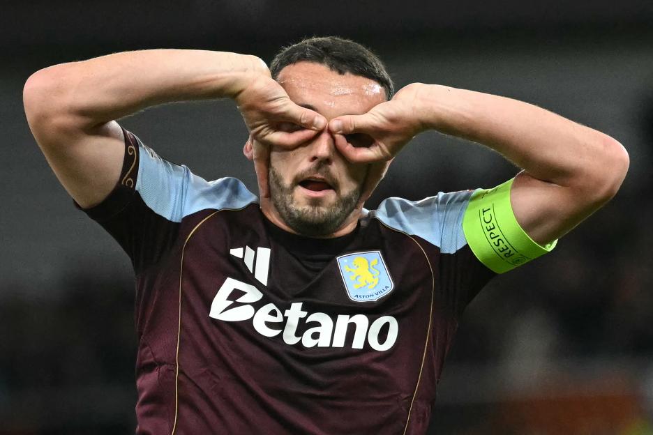 Aston Villa's Scottish midfielder John McGinn celebrates scoring a goal by putting his hands over his eyes like binoculars.
