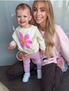 Woman and toddler girl sitting together.