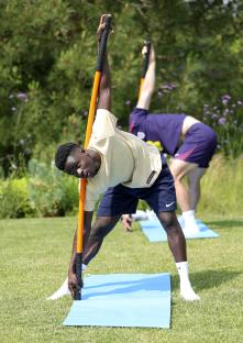Bukayo Saka and an England teammate stretching with long orange poles.