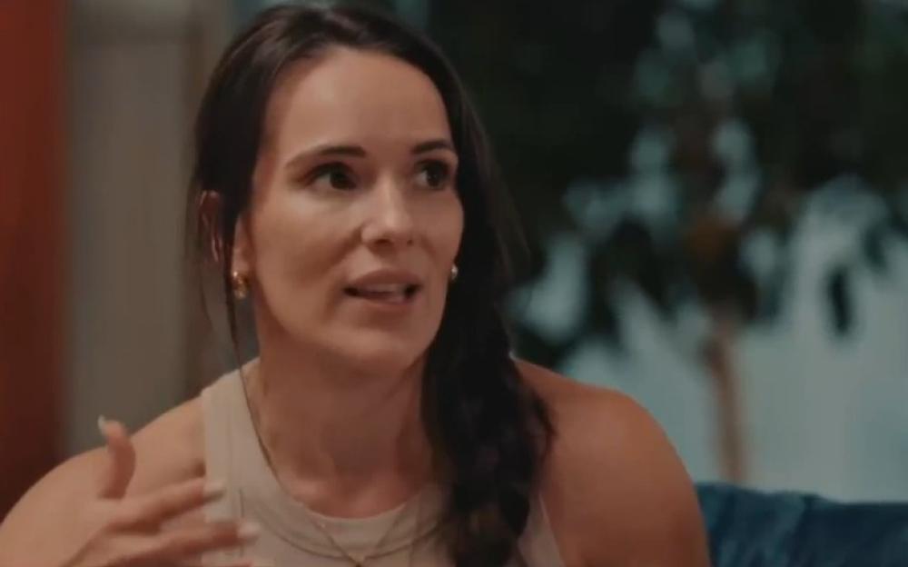 Woman in a light-colored top gesturing while speaking.