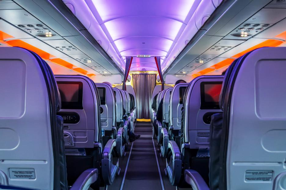 Airplane passenger cabin aisle at night.
