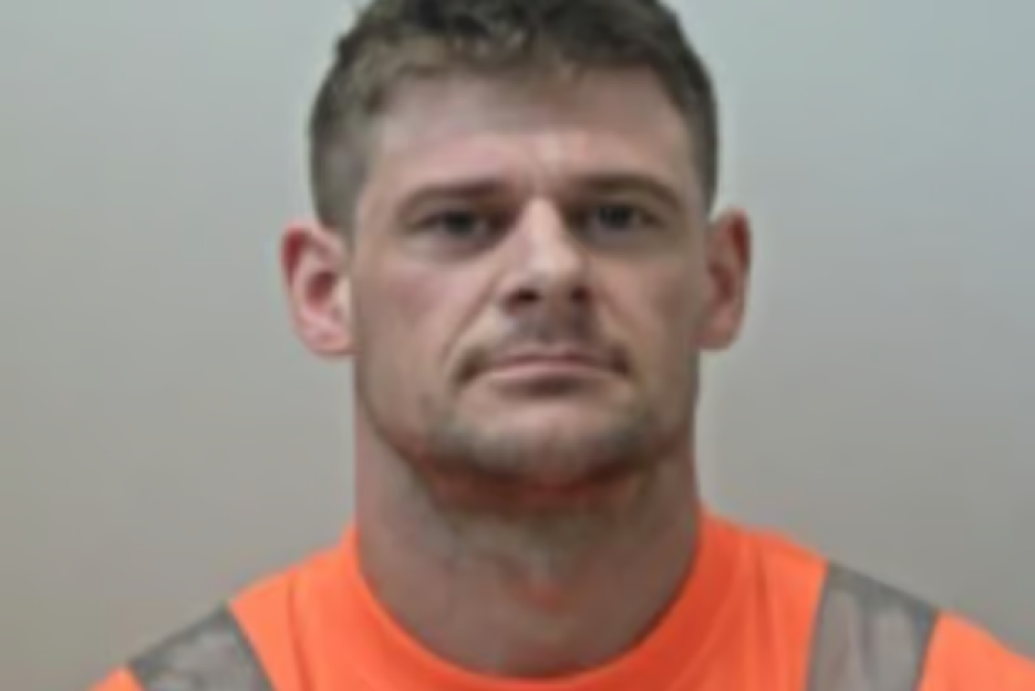 Mugshot of a man in an orange shirt.