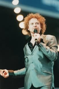 Mick Hucknall of Simply Red singing into a microphone.
