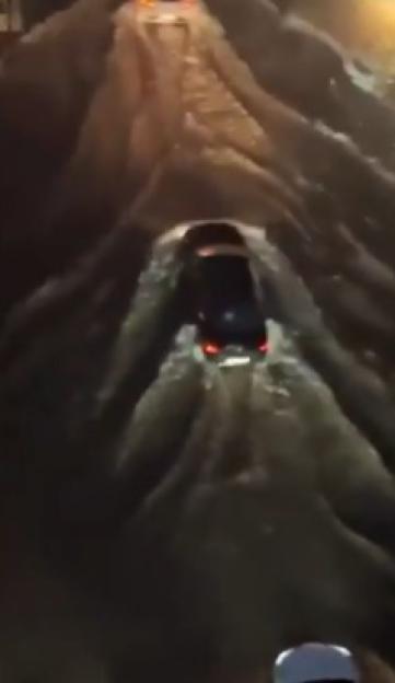 A car drives through a tunnel of thick ice.