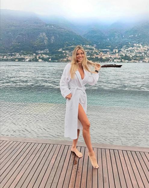 Diletta Leotta in a white bathrobe on a wooden deck by Lake Como.