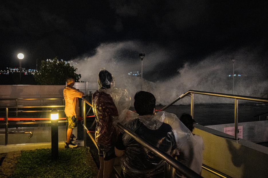Onlookers gather as waves crash while Super Typhoon Ragasa approaches Heng Fa Chuen residential district in Hong Kong.