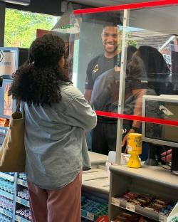 Anthony Joshua working a checkout at a Morrisons grocery store.