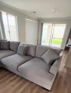 Large light grey sectional sofa in a living room.